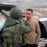 Un soldado israelí fotografía al activista palestino Rabia Abu Naim en Al-Mughayyir, Cisjordania ocupada.