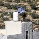 Colonos israelíes izan la bandera de Israel en la casa de Ahed Khatib, dentro de la Zona B cerca de Aqarba, en Cisjordania.