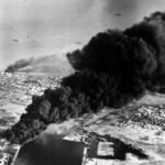 El humo se eleva desde los tanques de petróleo junto al Canal de Suez, alcanzado durante el asalto inicial anglo-francés a Port Said, el 5 de noviembre de 1956.