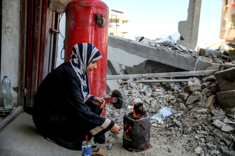 Una mujer cocina en Gaza en medio de ruinas, en una imagen tomada en septiembre de 2024.