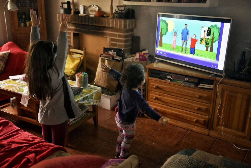 Dos niñas miran un programa infantil durante los días de confinamiento por coronavirus.