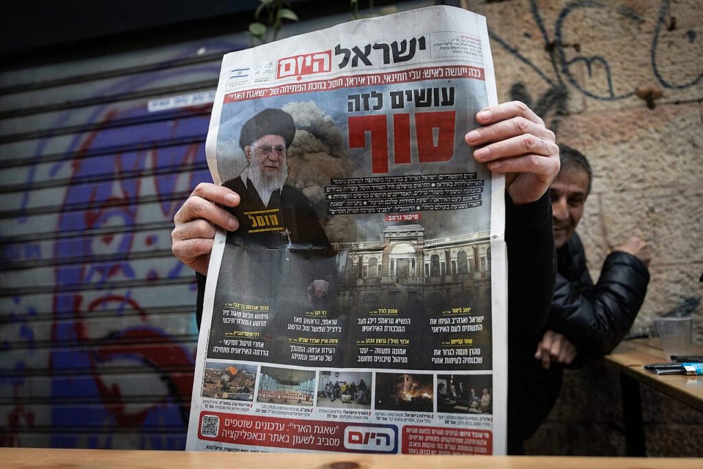 4Un hombre sostiene un ejemplar del diario hebreo Israel Hayom en el mercado Mahane Yehuda de Jerusalén, que presenta en su portada al líder supremo de Irán.