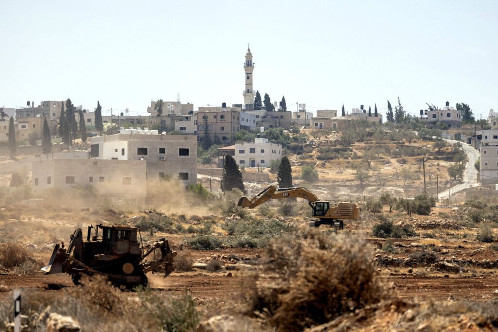 El 23 de agosto de 2025, excavadoras operadas por colonos y soldados israelíes arrancan olivos cerca de la aldea de Al-Mughayyir, en la Cisjordania ocupada.