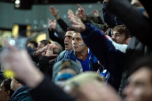 Un grupo de hombres viendo un partido de fútbol en la película Muy lejos.