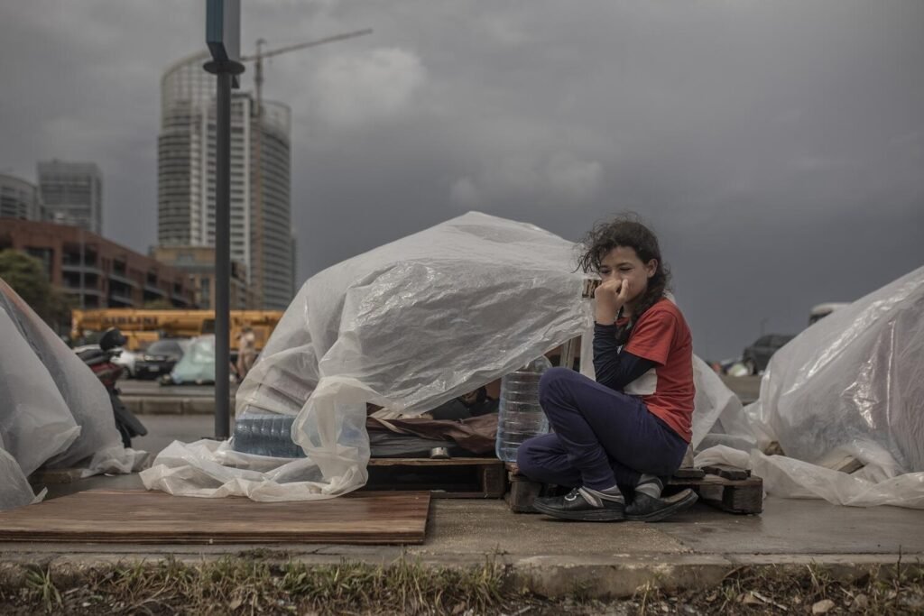 Yasmin, de 10 años, aguarda en un refugio improvisado con plásticos a orillas de una calle en Beirut.