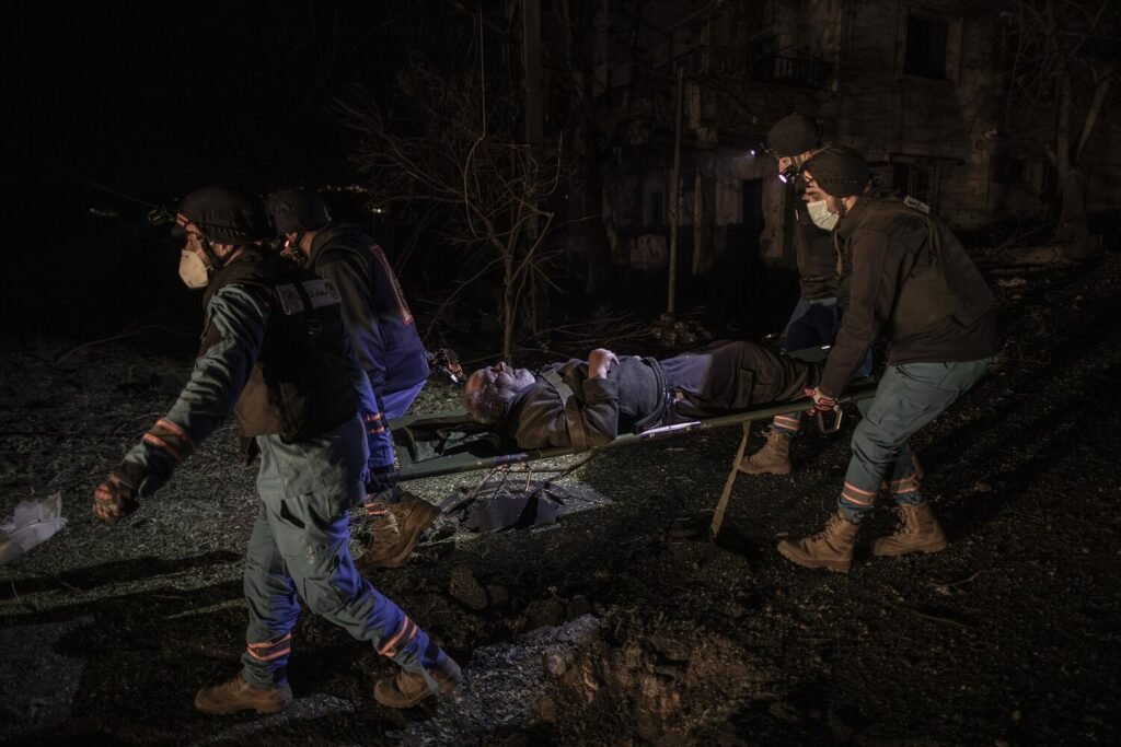 Paramédicos en Nabatieh evacúan de noche a un anciano en estado de shock tras el bombardeo de su vivienda.