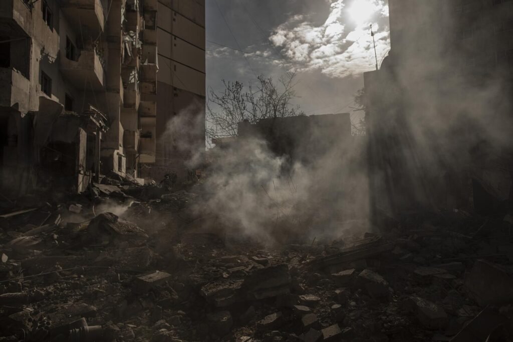Columnas de humo emergen de los escombros de un edificio tras un bombardeo israelí en Tiro, Líbano, el 24 de marzo de 2026.