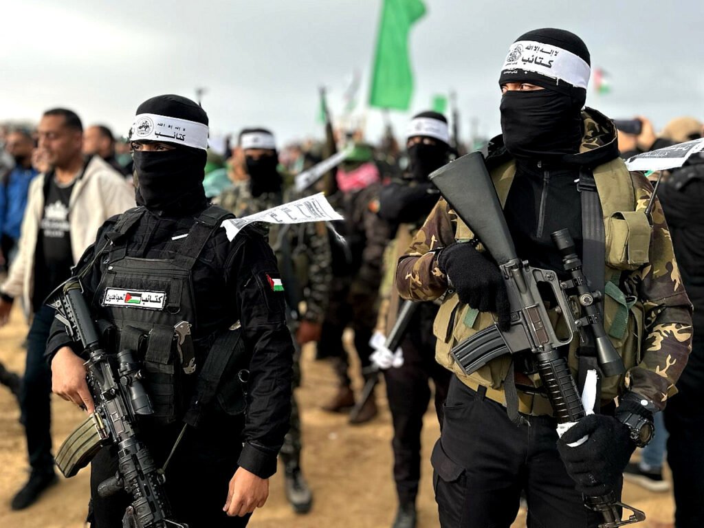 Milicianos de Hamás muestran su fuerza durante la entrega de los cuerpos de los rehenes a la Cruz Roja en Khan Younis, al sur de Gaza.