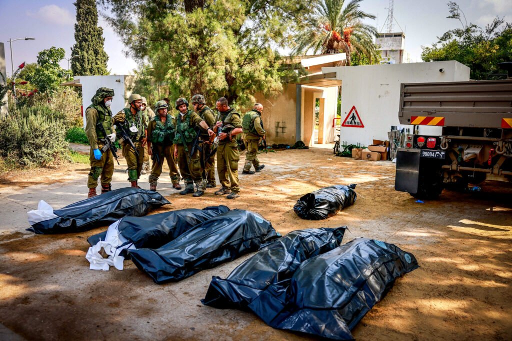 Soldados israelíes retiran los cuerpos de civiles israelíes en el kibutz Kfar Aza, cerca de la valla que separa Israel de Gaza, en el sur de Israel, el 10 de octubre de 2023.