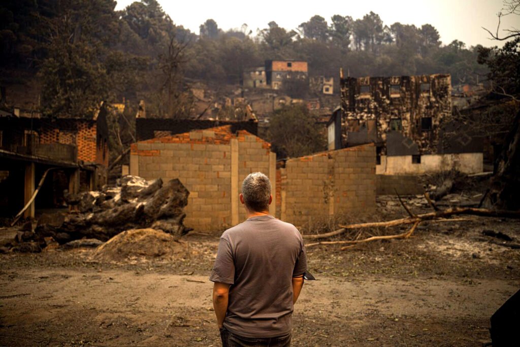 Un vecino observa los destrozos hechos por el fuego en la comarca de Valdeorras, Ourense, en el verano de 2025.