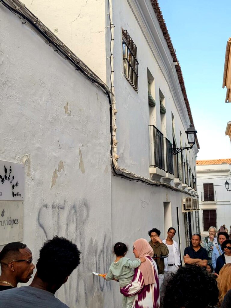 Una madre y su hija quitan la pintada racista en la sede de la Fundación Ruy López en Almendralejo.