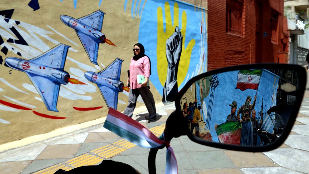 Una mujer pasa junto a un mural antiestadounidense y antiisraelí en Teherán este 21 de abril de 2026.