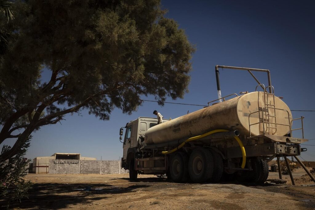 Un camión cisterna de la Agencia de las Naciones Unidas para los Refugiados (ACNUR) llena el tanque en un punto de abastecimiento para luego llevar agua a los diferentes campamentos. El abastecimiento de agua es uno de los principales retos para los saharauis refugiados en Argelia, donde un 70% de la población depende de su transporte en camiones cisterna. Los recortes en ayuda humanitaria impulsados por la Administración de Donald Trump en Estados Unidos han obligado a reducir el personal y el número de camiones disponibles en los campamentos saharauis. Jairo Vargas.