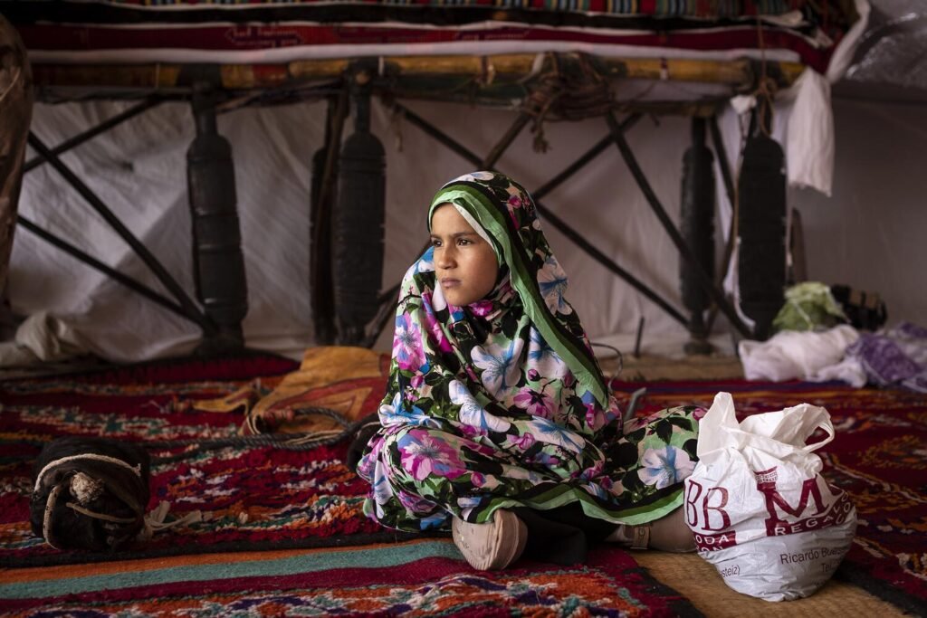 Un niña saharaui sentada dentro de una jaima tradicional expuesta durante el Fisahara de 2026 en el campamento de Auserd. Jairo Vargas.