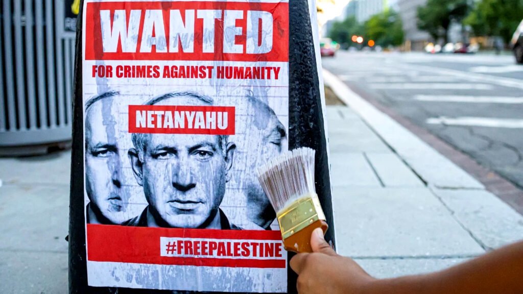 Un activista pega un cartel en la base de una farola en protesta contra la visita del primer ministro israelí Benjamin Netanyahu.
