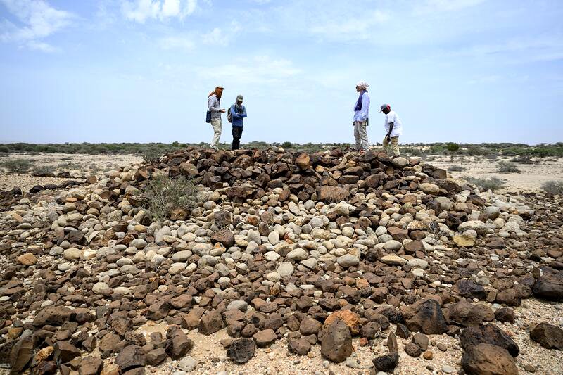 Alfredo González-Ruibal, arqueólogo, junto a parque de su equipo, sobre uno de los túmulos funerarios objeto de su investigación en Somalilandia el mes de abril de 2026.