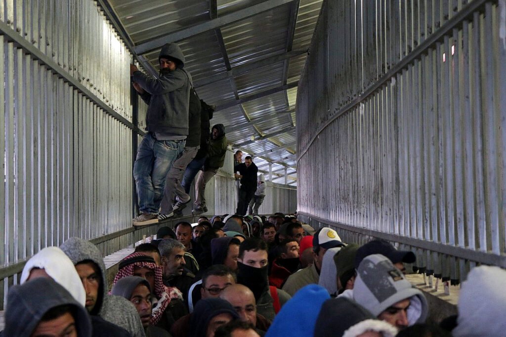 Trabajadores palestinos se abren paso a duras penas por un puesto de control israelí para dirigirse a sus puestos de trabajo en ciudades israelíes, Belén, Cisjordania,