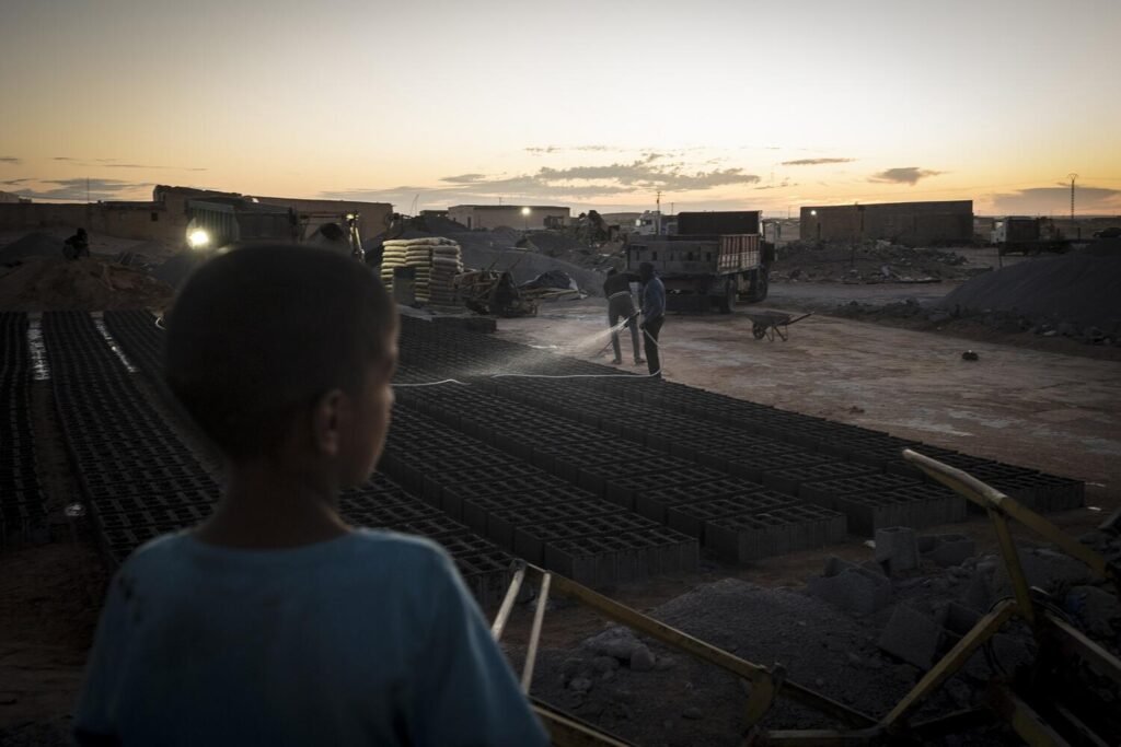 Un niño observa cómo se humedecen bloques de cemento que servirán para construir nuevas casas en el campamento de refugiados de Auserd, donde viven más de 36.000 saharauis, alrededor de un 20% de la población refugiada en Argelia. Jairo Vargas.