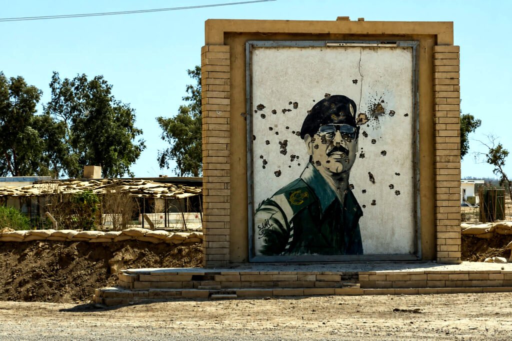 Un retrato de Saddam Hussein con varios impactos de bala.