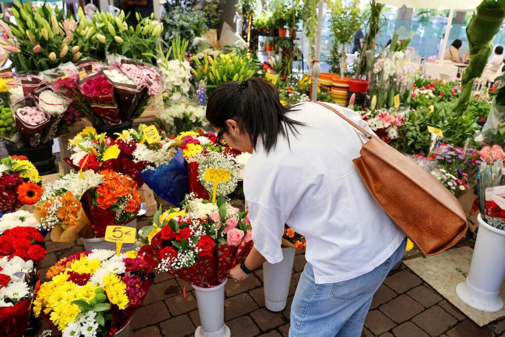 Dalisay elige flores en un mercado local de Madrid.