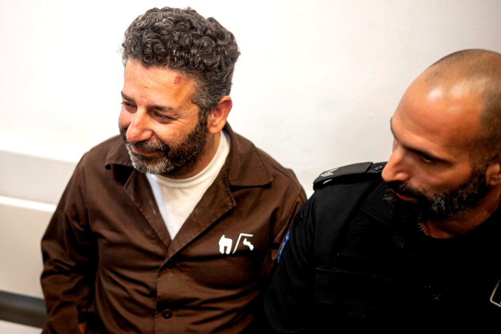 El activista palestino-español Saïf Abukeshek escoltado por un policía israelí.