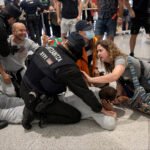 La Ertzaintza carga contra activistas de la Flotilla en el aeropuerto de Bilbao.