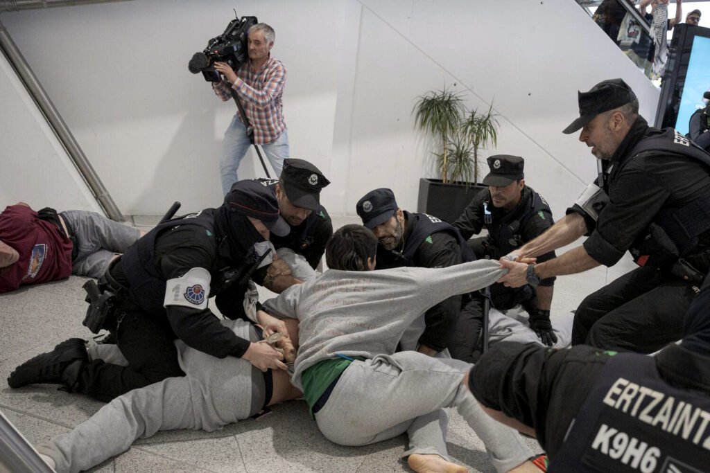 La Erztzaintza carga contra los militantes de la flotilla a su llegada al aeropuerto de Loiu.