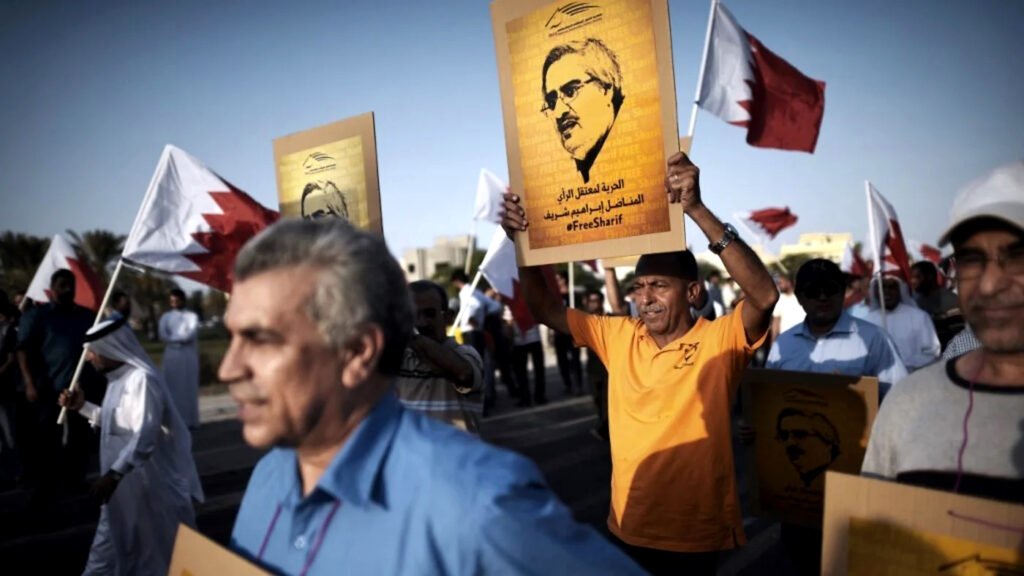 Manifestantes bareiníes alzan pancartas con el retrato del activista político encarcelado Ebrahim Sharif durante una protesta antigubernamental.