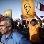Manifestantes bareiníes alzan pancartas con el retrato del activista político encarcelado Ebrahim Sharif durante una protesta antigubernamental.