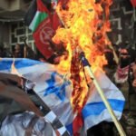 Manifestantes palestinos queman la bandera de Israel.