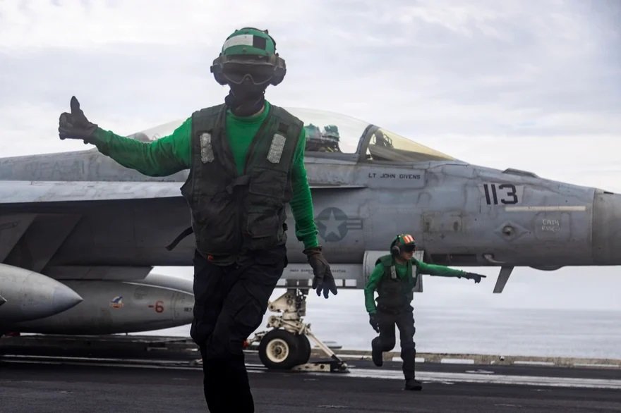 Marineros estadounidenses realizan las últimas comprobaciones a un F/A-18F Super Hornet, perteneciente al Escuadrón de Caza de Ataque (VFA) 41, mientras se prepara para despegar de la cubierta de vuelo del portaaviones de clase Nimitz USS Abraham Lincoln (CVN 72) durante la Operación Furia Épica, el 23 de marzo de 2026..