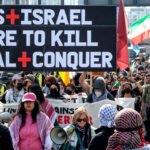 Manifestantes sostienen una pancarta durante la concentración. Se congregaron frente a la Embajada de Estados Unidos en Nine Elms para protestar contra las acciones militares estadounidenses e israelíes en Oriente Medio.
