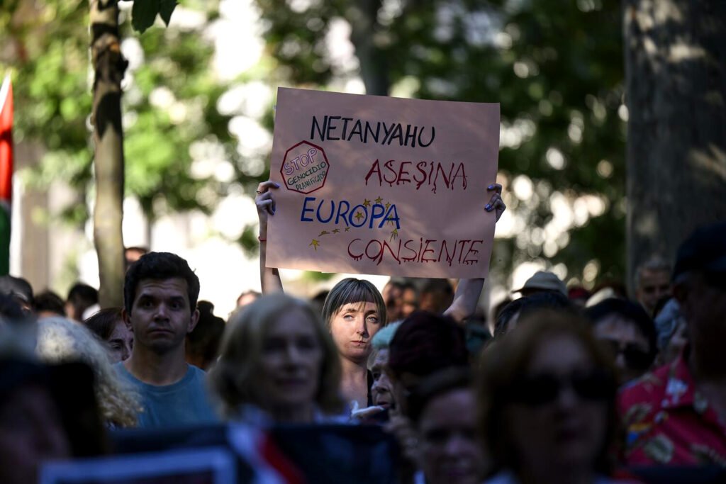 Una mujer sostiene un cartel en defensa del pueblo palestino y contra el genocidio gazatí.