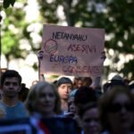Una mujer sostiene un cartel en defensa del pueblo palestino y contra el genocidio gazatí.
