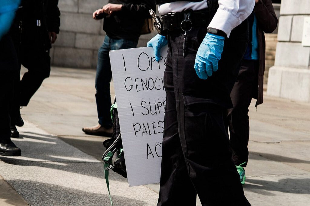 La policía sostiene una pancarta confiscada en apoyo a Palestine Action durante una manifestación organizada por Defend Our Juries en Trafalgar Square, Londres.