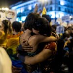 Dos manifestantes se abrazan.