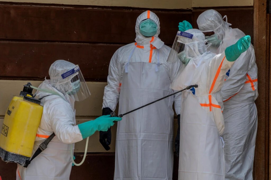 Personal sanitario se desinfecta tras preparar el cuerpo de una víctima de ébola en un hospital congoleño.