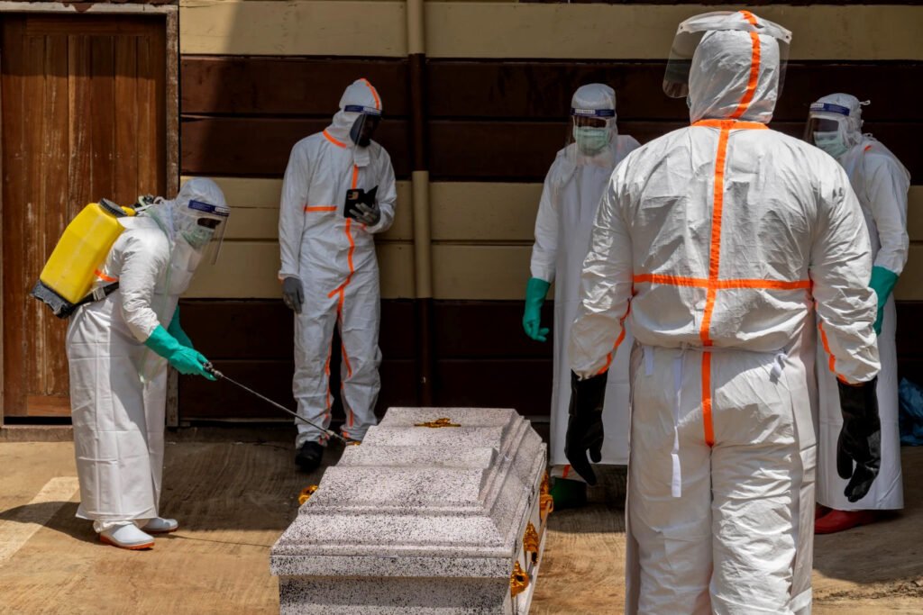 Personal sanitario prepara el ataud de una víctima de ébola.
