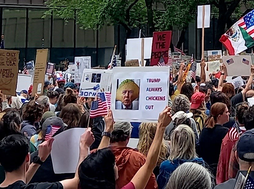 Un cártel sobre el TACO es visible durante la protesta No Kings en Chicago.