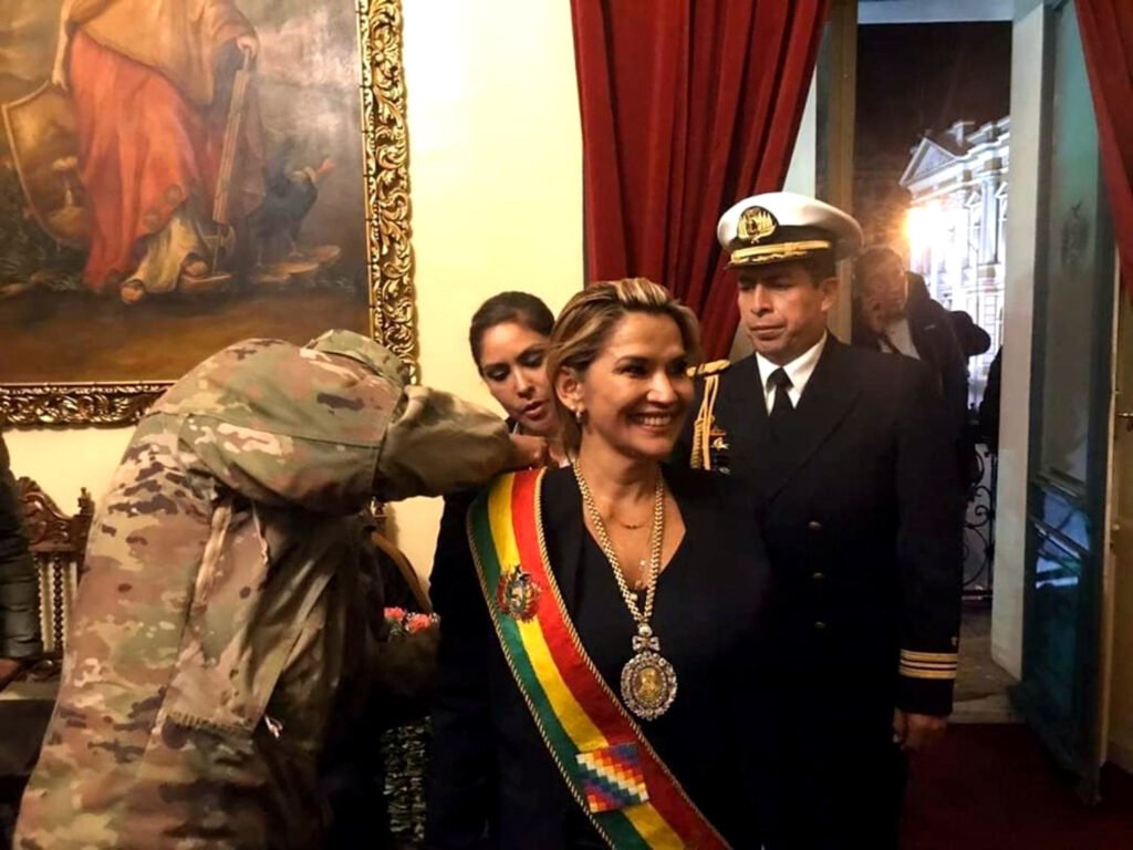 Un militar coloca la banda presidencial a la flamante presidenta de Bolivia, Jeanine Áñez, designada sin la participación de la Asamblea Legislativa, en donde el MAS tiene mayoría absoluta.
