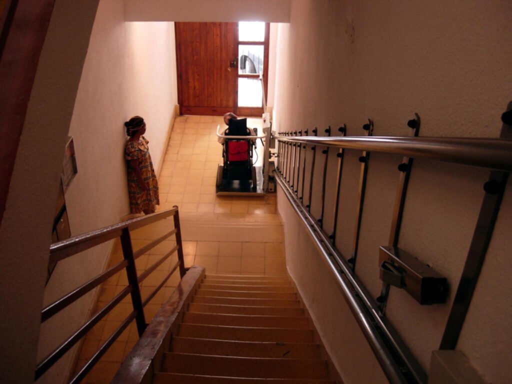 Una persona baja por una escalera adaptada a personas con movilidad no normativa, instalaciones que no todos los edificios tienen.