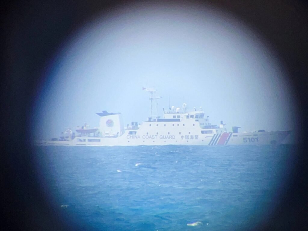 Un buque de la Guardia Costera china se divisa en el horizonte a través de una imagen telescópica cerca de la isla Thitu, ocupada por Filipinas, en el disputado Mar de China Meridional.