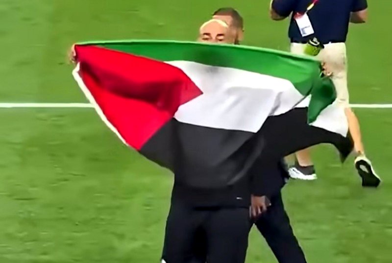 El seleccionador egipcio, Hossam Hassan, muestra la bandera palestina tras su victoria ante Australia en el Mundial.