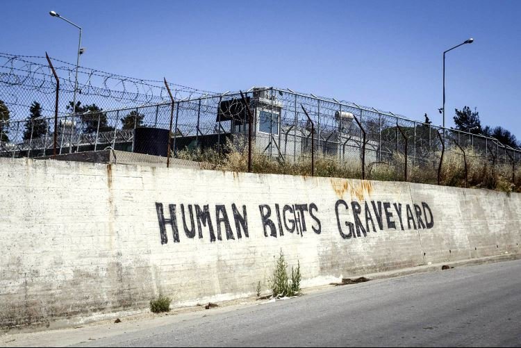 'El cementerio de los derechos humanos', escrito en una pared del antiguo centro para solicitantes de asilo de Moria, que se incendió en septiembre de 2020. Moria. Lesbos. Grecia. 2023.