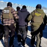 Dos agentes del ICE se llevan a un hombre detenido en Minnesota, en enero de 2026.