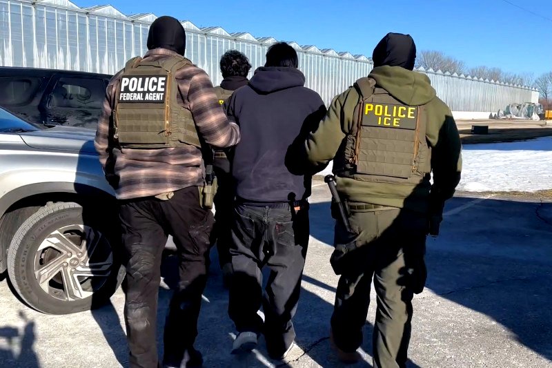 Dos agentes del ICE se llevan a un hombre detenido en Minnesota, en enero de 2026.