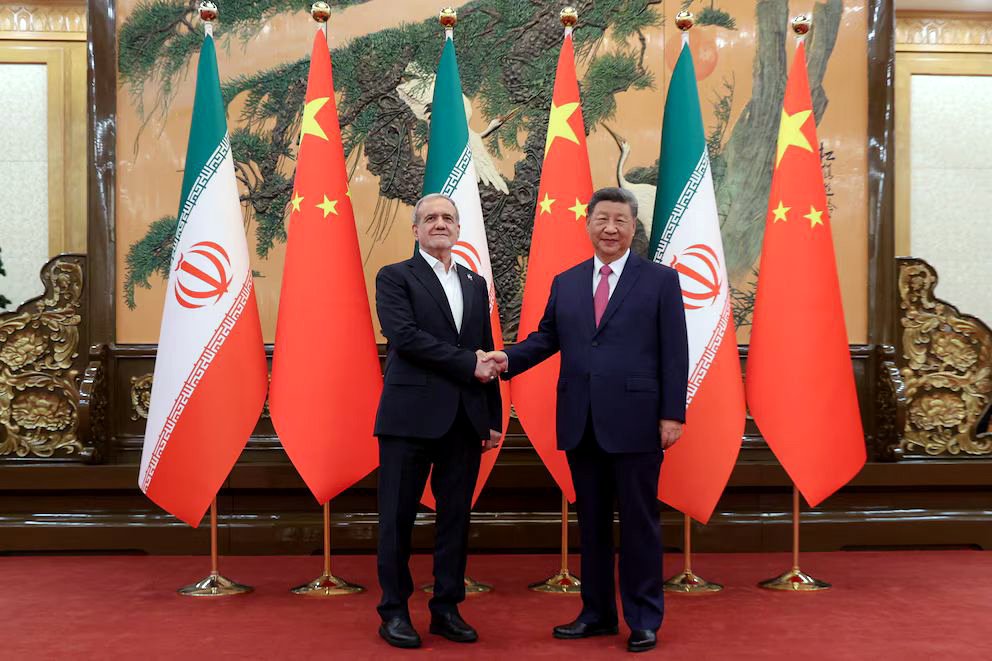 El presidente iraní Masoud Pezeshkian y el presidente chino Xi Jinping se dan la mano durante un encuentro en Pekín, China.