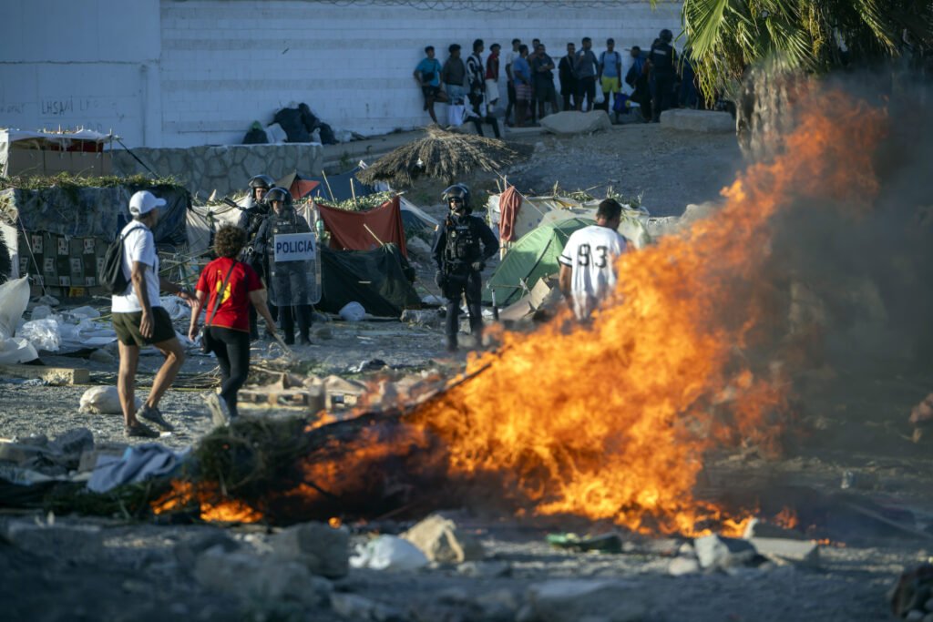 Mobiliario urbano y enseres arden en Ceuta durante una manifestación para protestar por la situación provocada por la llegada masiva de migrantes. 27.08.2026.