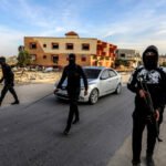 Palestinos armados y enmascarados escoltan vehículos cargados de ayuda humanitaria en Gaza el 19 de enero de 2025.