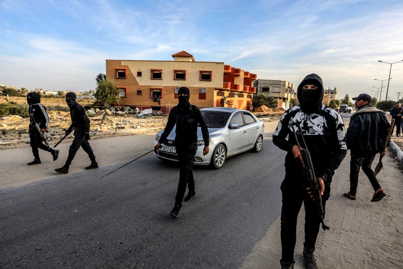 Palestinos armados y enmascarados escoltan vehículos cargados de ayuda humanitaria en Gaza el 19 de enero de 2025.